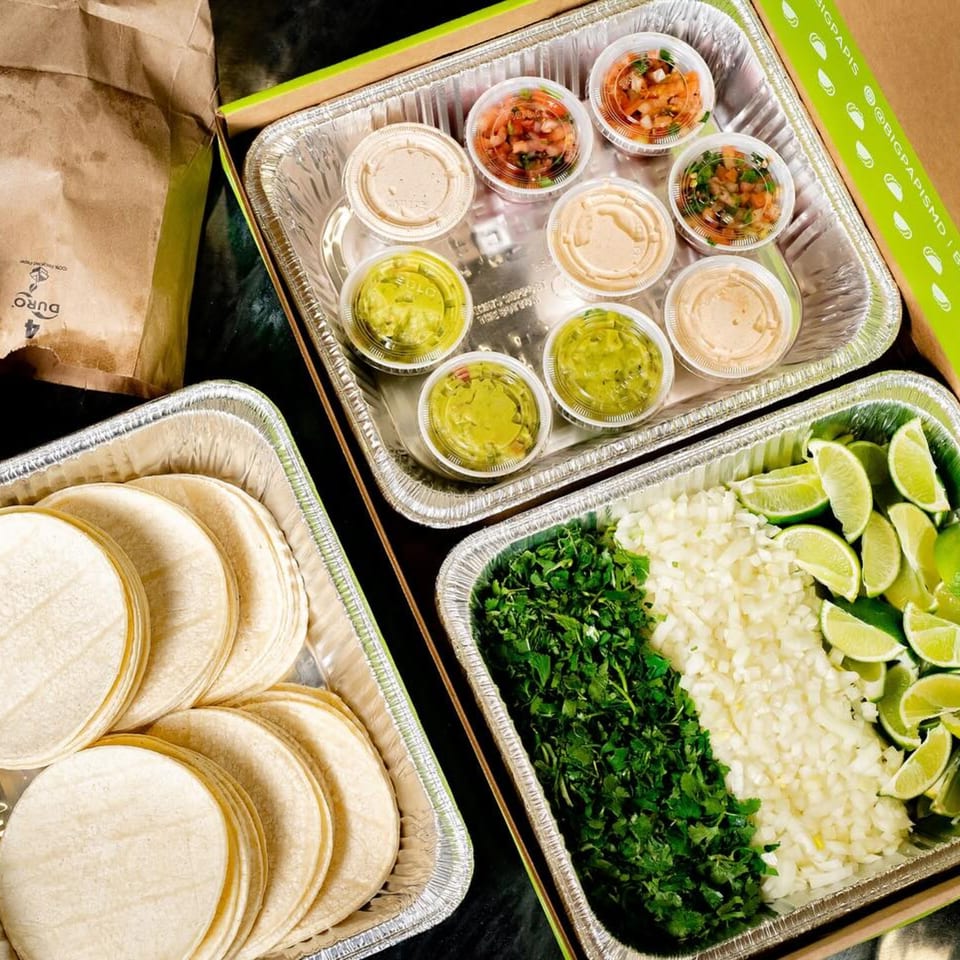 Big Papi's taco kit with tortillas, cilantro, onions, limes, guacamole, salsa, and sauces.